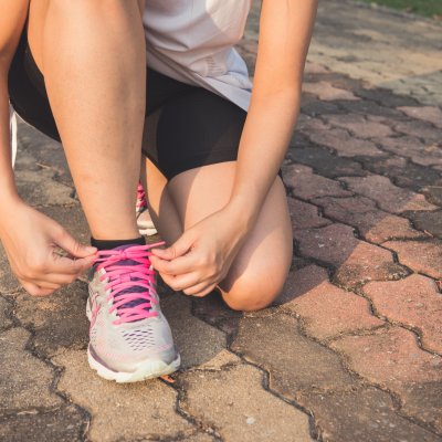 Woman tying shoelace.